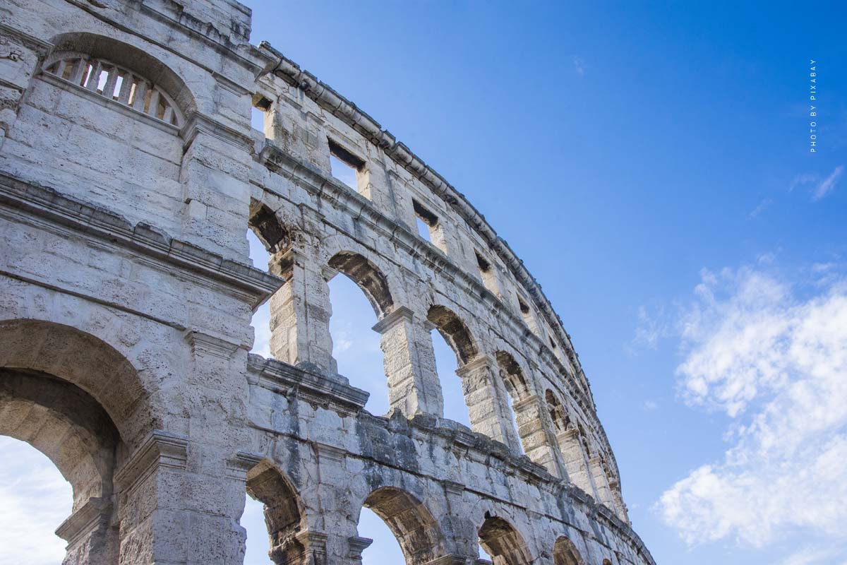 Uno sguardo al Colosseo a Roma con il cielo blu sullo sfondo.
