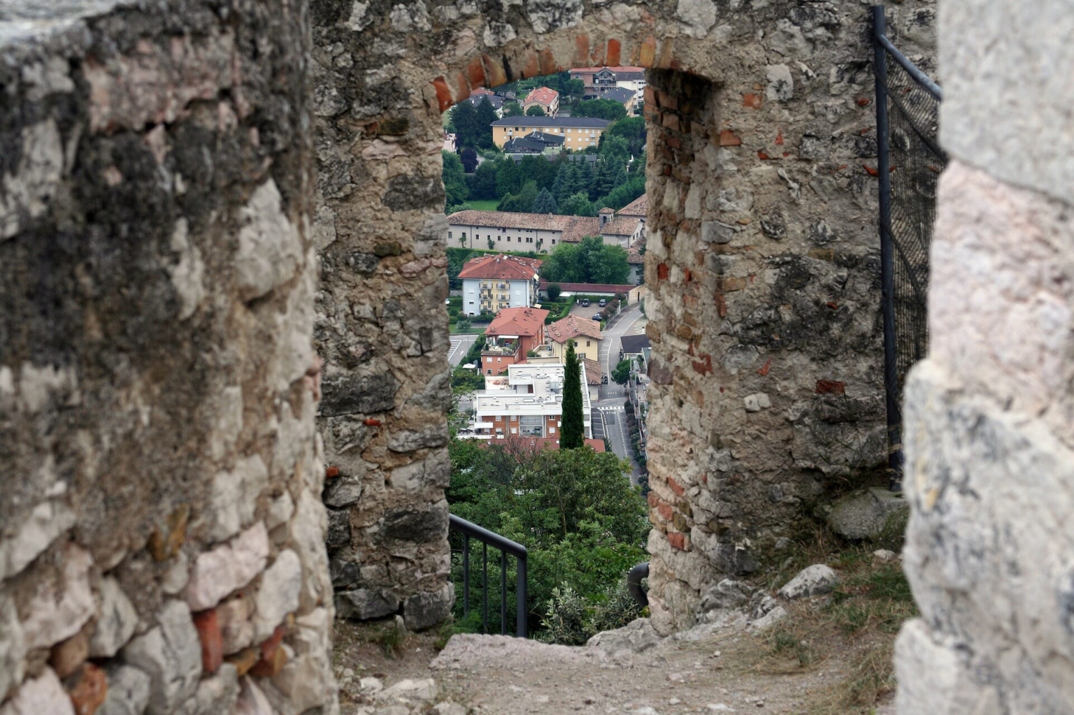 Attraverso un vecchio portone si intravede la piccola città sullo sfondo