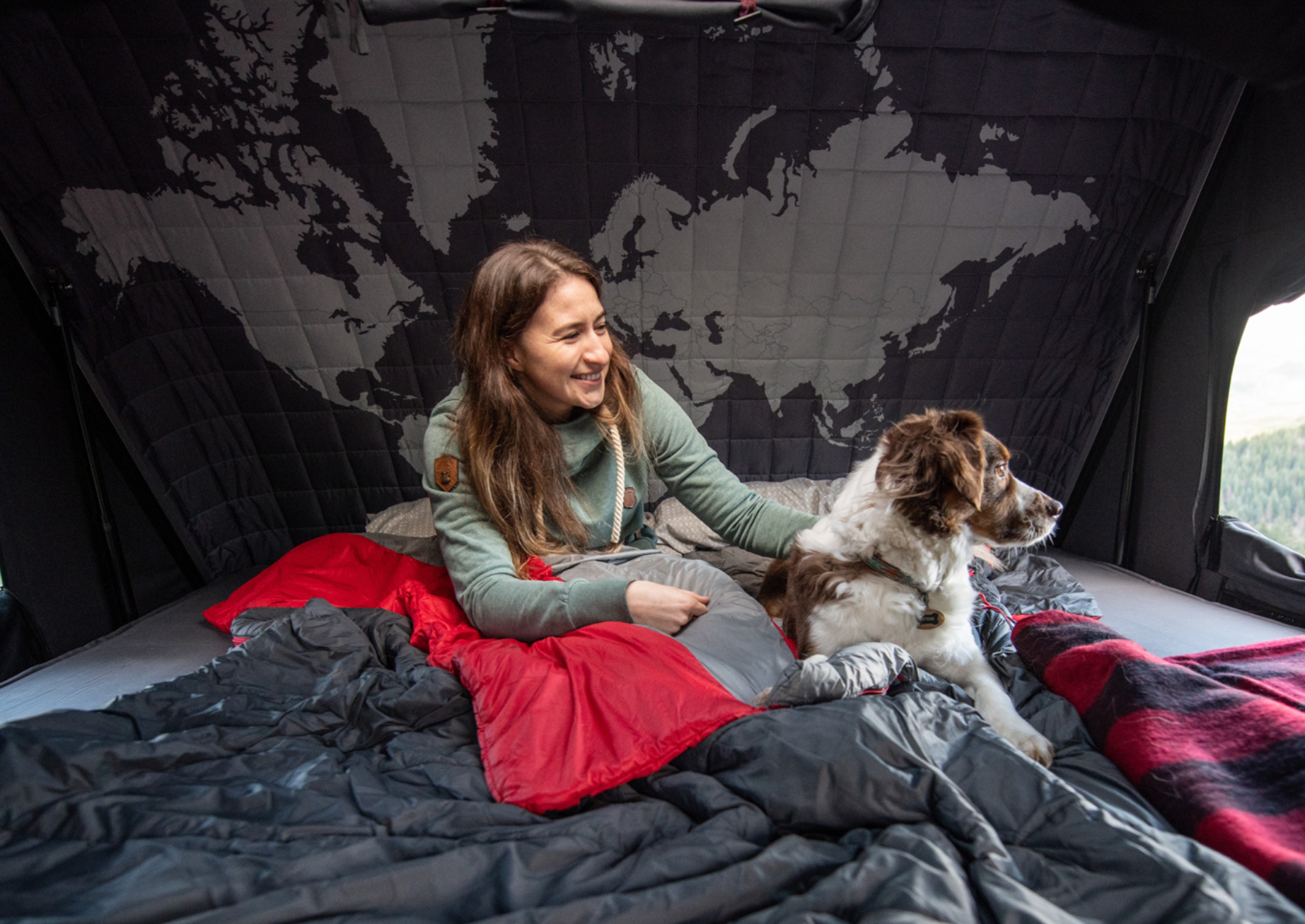 Donna seduta con il suo cane in una tenda da tetto rigida per 1 persona