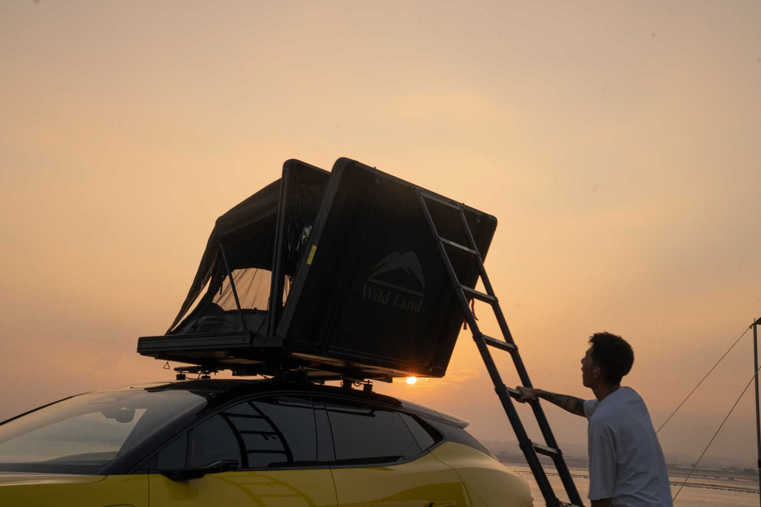 Un campeggiatore sale nella sua tenda da tetto